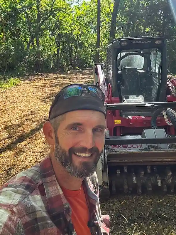 Solid Ground operator using a Takeuchi TL12 with forestry mulcher attachment to clear brush and small trees